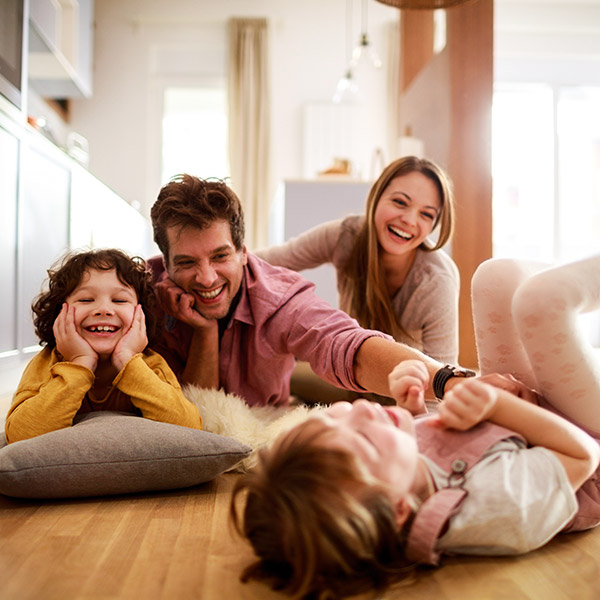 family laughing on their kitchen floor
