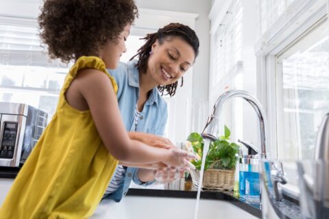 Mom and Daughter Washing Hands In Sink