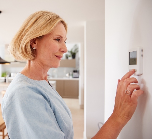 Woman Adjusting Thermostat