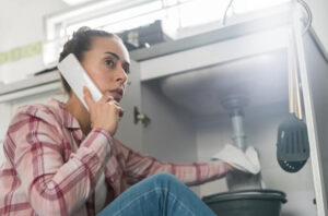 Women Calling Plumber During Emergency