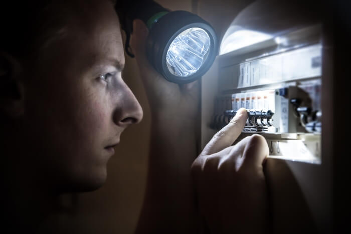 Man trying to fix the circuit breaker after it Trips