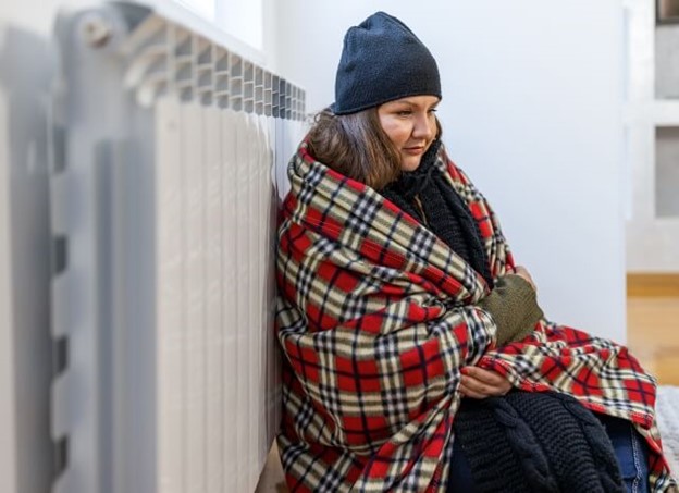 A woman in Provo and Orem UT, is wearing a blanket because the furnace of her house is not working.
